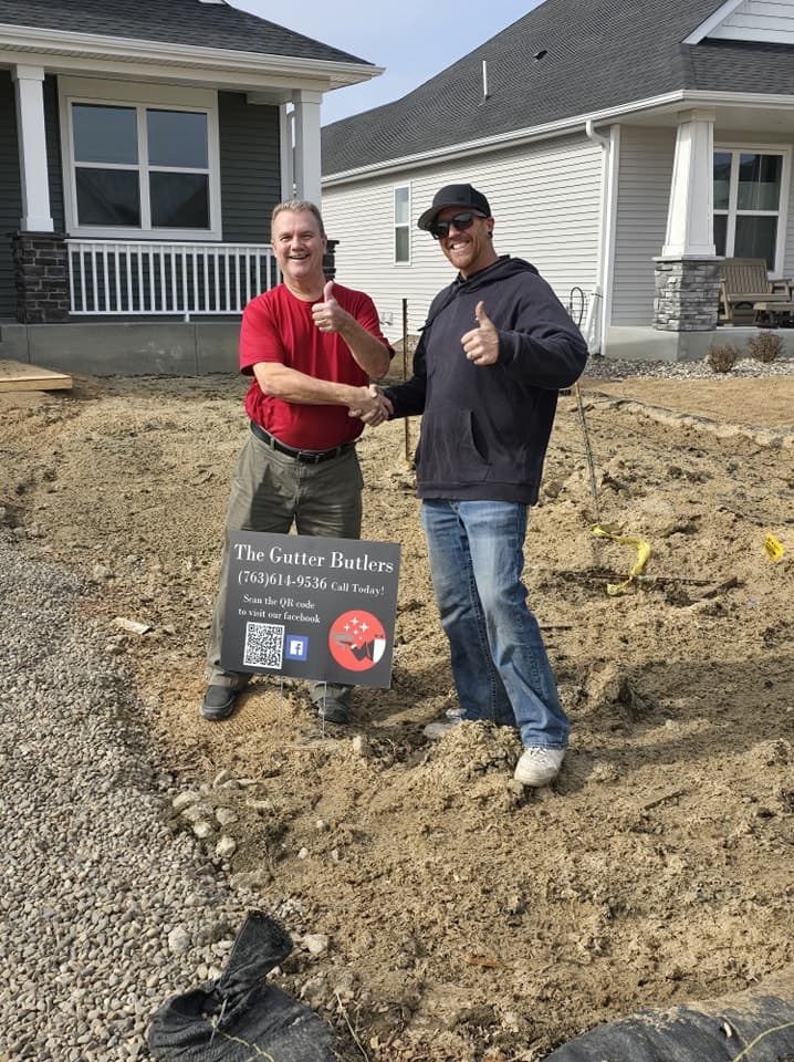 Derek shaking hands with a customer in front of newly built home