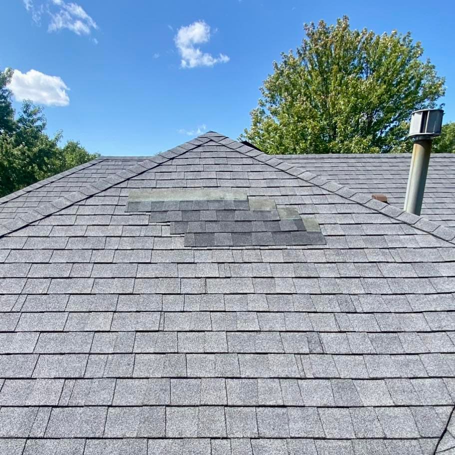 Storm-damaged roof with missing and creased shingles